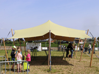 Stijlvolle feesttent met beige stretchdoek en houten palen