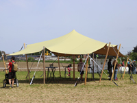 Stijlvolle feesttent met beige stretchdoek en houten palen