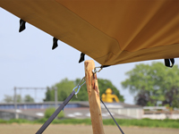 Stijlvolle feesttent met beige stretchdoek en houten palen