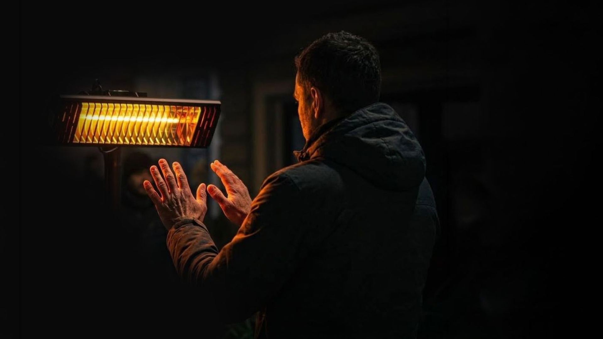 Persoon warmt handen aan een tent heater